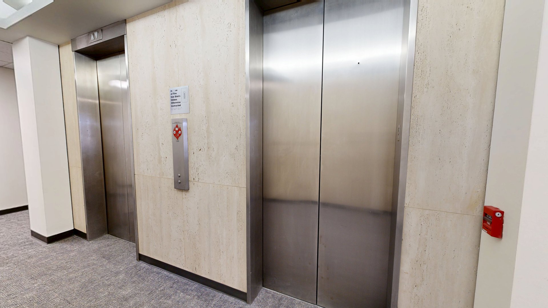 The elevator lobby at 1800 St. James Place: stone walls, no operator signage