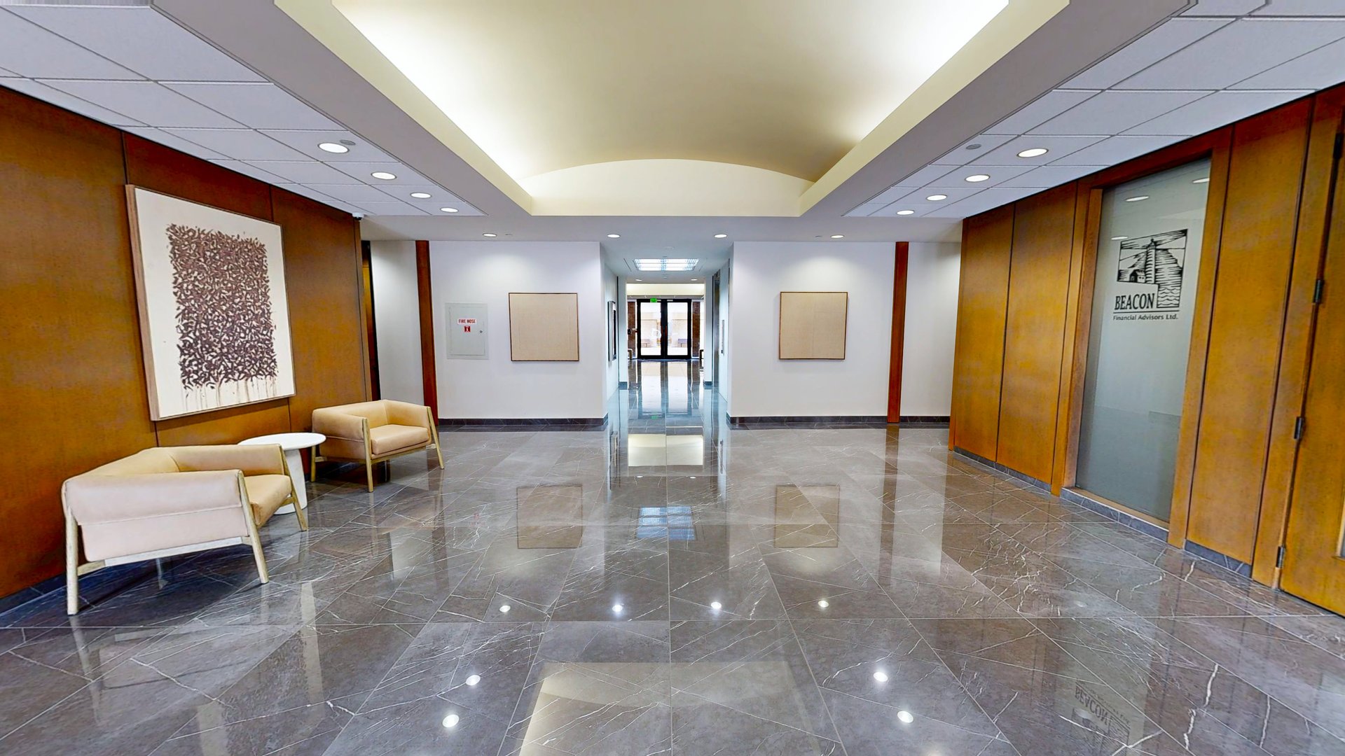 The real ground-floor lobby at 1800 St. James Place: marble floor, wood paneling, tenant suite entrances
